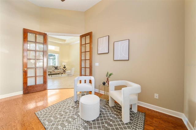 sitting room with hardwood / wood-style flooring and french doors