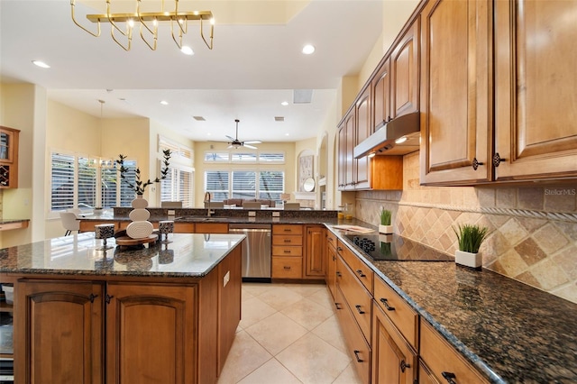 kitchen featuring dishwasher, black electric stovetop, ceiling fan with notable chandelier, decorative light fixtures, and kitchen peninsula