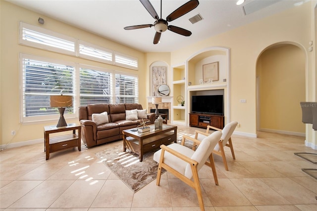 tiled living room with built in shelves and ceiling fan