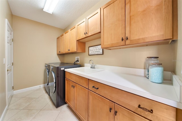 laundry room featuring sink, cabinets, independent washer and dryer, a textured ceiling, and light tile patterned floors