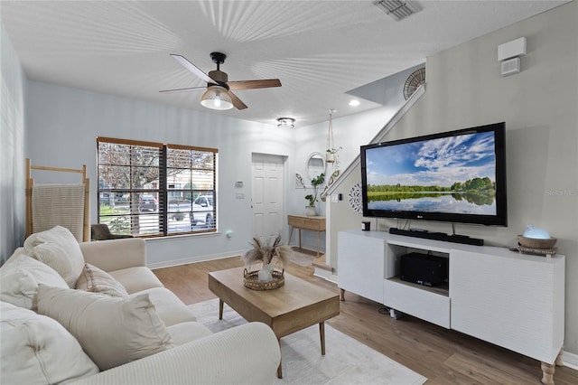 living room featuring ceiling fan and hardwood / wood-style floors