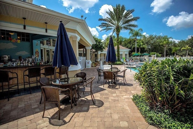 view of patio / terrace featuring exterior bar and a community pool