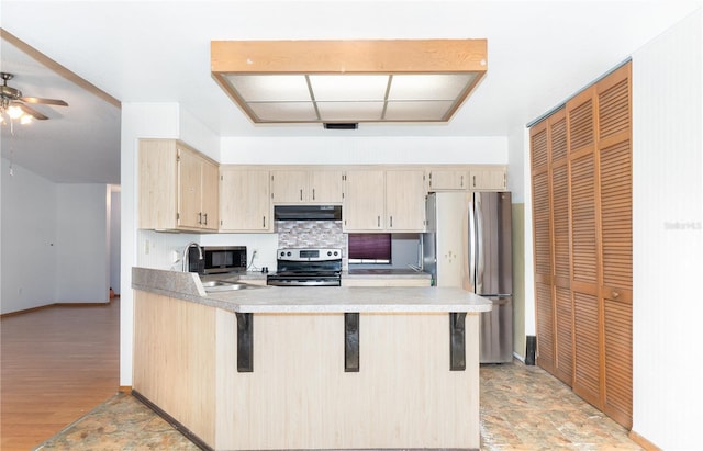 kitchen featuring sink, ceiling fan, light brown cabinetry, kitchen peninsula, and stainless steel appliances