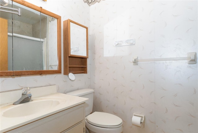 bathroom featuring vanity, a shower with shower door, and toilet