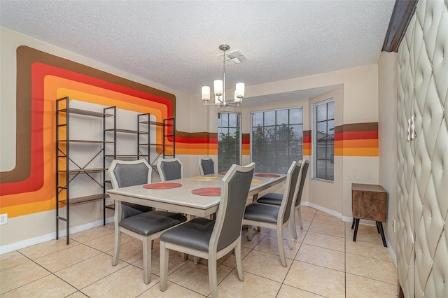 tiled dining area featuring a notable chandelier and a textured ceiling