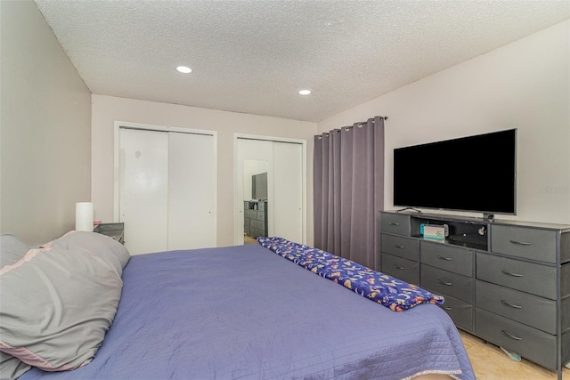 bedroom featuring a textured ceiling and multiple closets