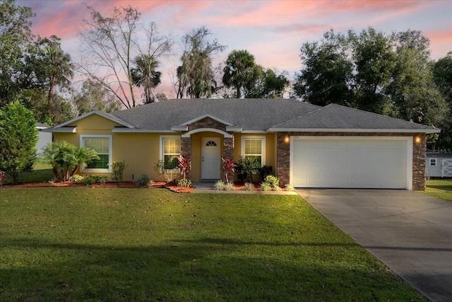 single story home featuring a garage and a yard