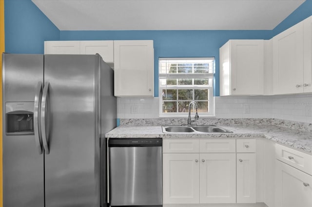 kitchen with sink, light stone counters, backsplash, white cabinets, and appliances with stainless steel finishes