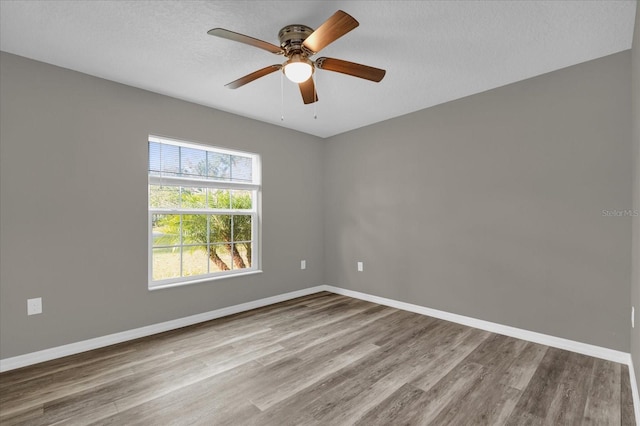 spare room with a textured ceiling, light hardwood / wood-style floors, and ceiling fan