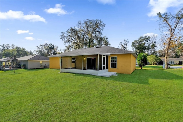 rear view of house featuring a lawn and a sunroom