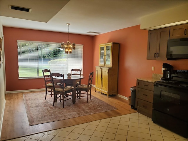 dining space featuring light hardwood / wood-style flooring and a notable chandelier