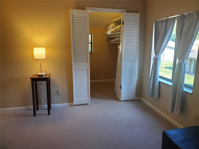 unfurnished bedroom featuring a spacious closet, a closet, and carpet floors