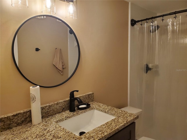 bathroom with curtained shower, vanity, and toilet