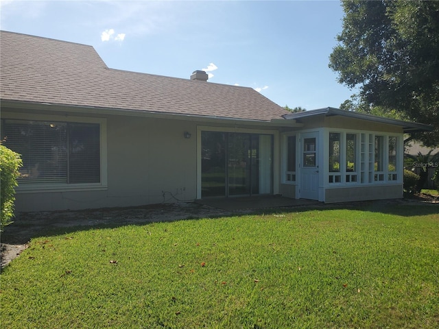 rear view of property with a lawn