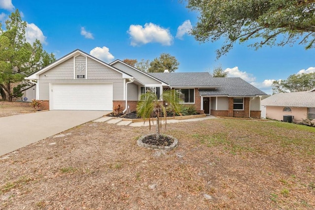 ranch-style house featuring a garage, central AC unit, and a front lawn