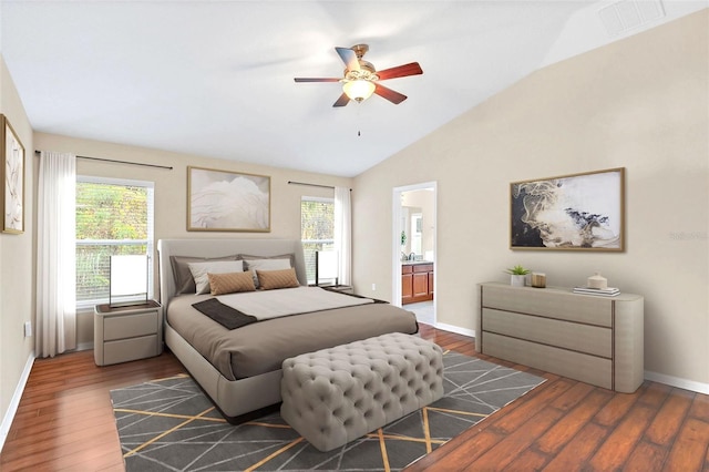 bedroom with ceiling fan, vaulted ceiling, connected bathroom, and multiple windows