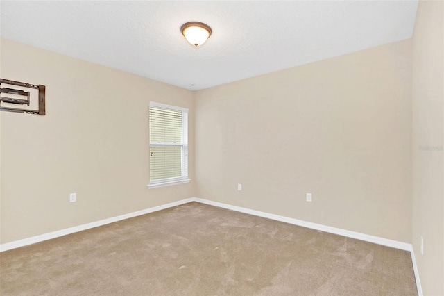 spare room with a textured ceiling and light carpet