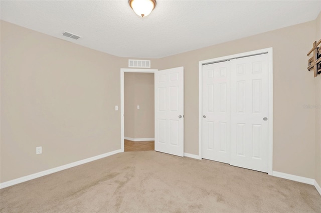 unfurnished bedroom with light carpet and a closet