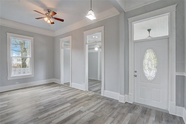 foyer with light hardwood / wood-style flooring, ceiling fan, and crown molding