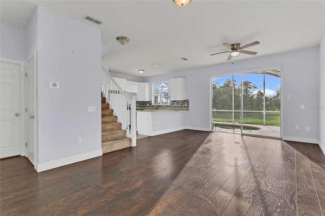 unfurnished living room with dark hardwood / wood-style flooring and ceiling fan