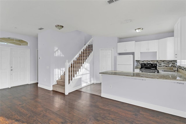 kitchen featuring white cabinetry, sink, stainless steel range, and white refrigerator