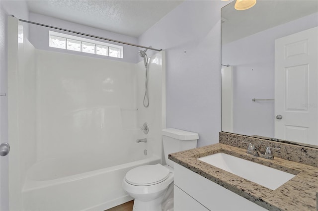 full bathroom with vanity, tub / shower combination, toilet, and a textured ceiling