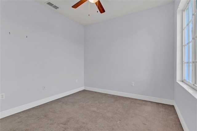 spare room featuring light carpet and ceiling fan