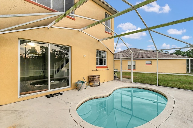 view of swimming pool featuring a patio area, a lanai, and a lawn