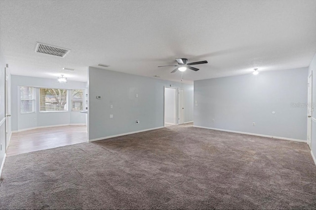 carpeted empty room featuring a textured ceiling and ceiling fan