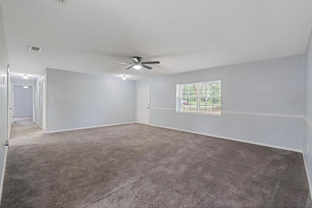 carpeted empty room with ceiling fan and a textured ceiling