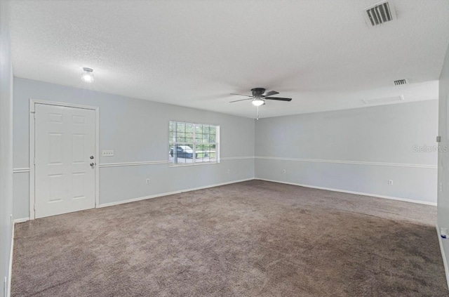 carpeted spare room with a textured ceiling and ceiling fan