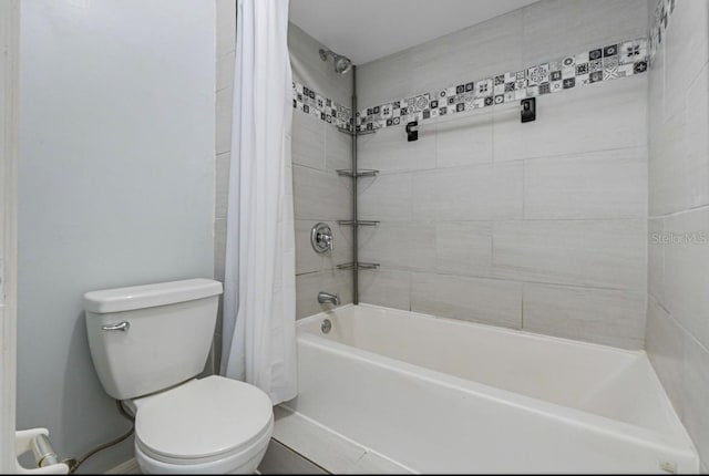 bathroom featuring shower / tub combo and toilet