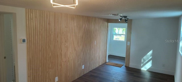 empty room featuring ceiling fan, a textured ceiling, and dark hardwood / wood-style floors