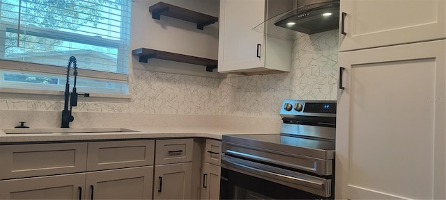 kitchen featuring tasteful backsplash, exhaust hood, stainless steel electric range, sink, and gray cabinetry