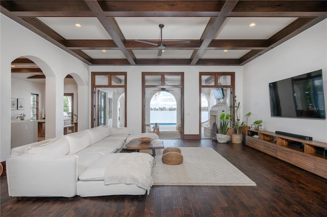 living room featuring beamed ceiling, dark wood-type flooring, ceiling fan, and coffered ceiling