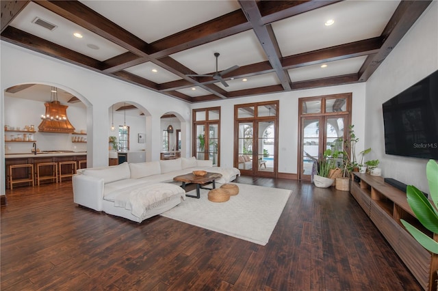 living room featuring french doors, beamed ceiling, dark wood-type flooring, and coffered ceiling