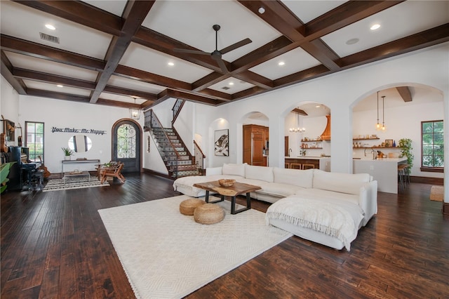 living room featuring beamed ceiling, dark hardwood / wood-style floors, a healthy amount of sunlight, and coffered ceiling