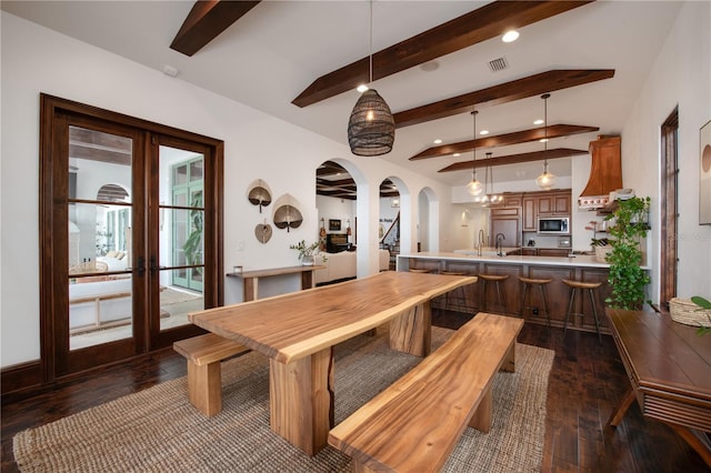 dining space with french doors, sink, beamed ceiling, and dark hardwood / wood-style floors