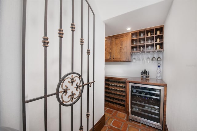 bar featuring dark tile patterned floors and beverage cooler