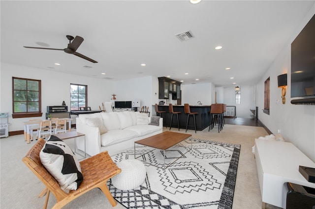 living room featuring light carpet and ceiling fan