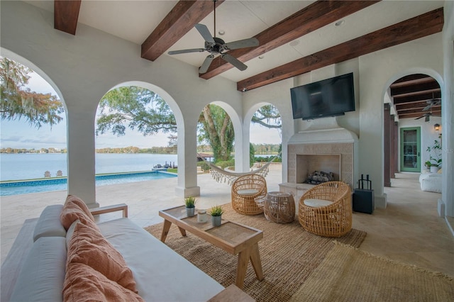 view of patio featuring an outdoor living space with a fireplace, ceiling fan, and a water view