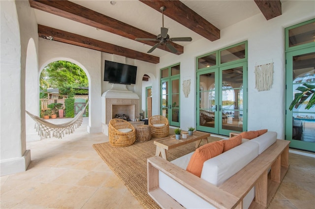 view of patio / terrace with an outdoor living space with a fireplace, french doors, and ceiling fan