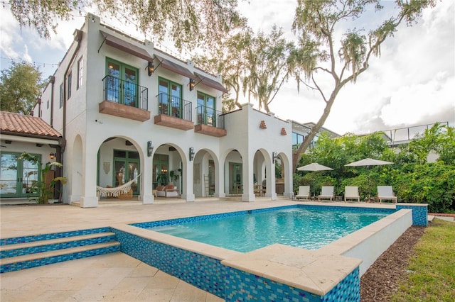 rear view of house with a patio area and a balcony