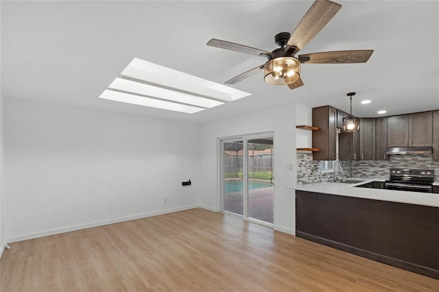 kitchen featuring dark brown cabinetry, ceiling fan, sink, pendant lighting, and stainless steel electric stove