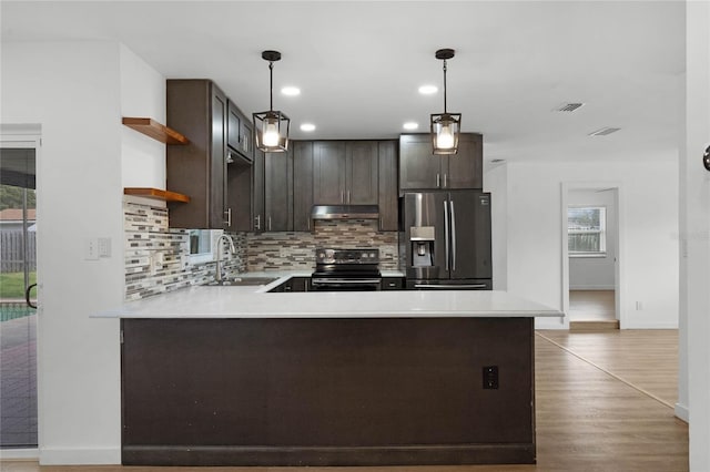 kitchen with kitchen peninsula, pendant lighting, stainless steel appliances, and sink