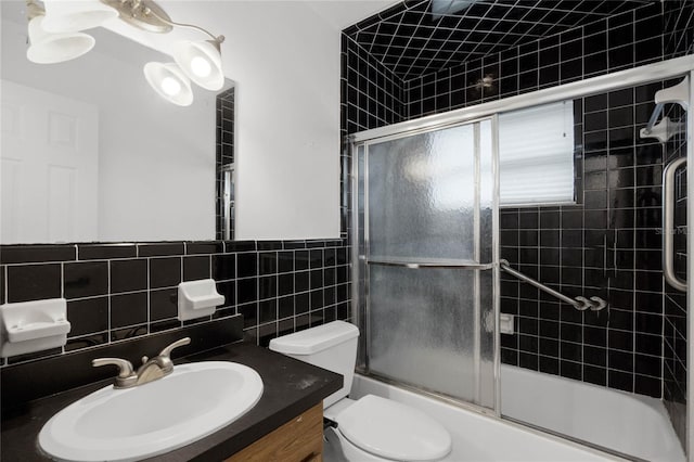 full bathroom with enclosed tub / shower combo, backsplash, toilet, vanity, and tile walls