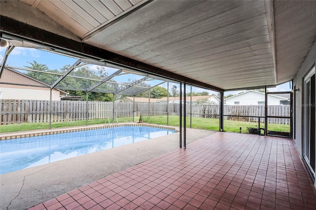 view of pool featuring a lawn, glass enclosure, and a patio area