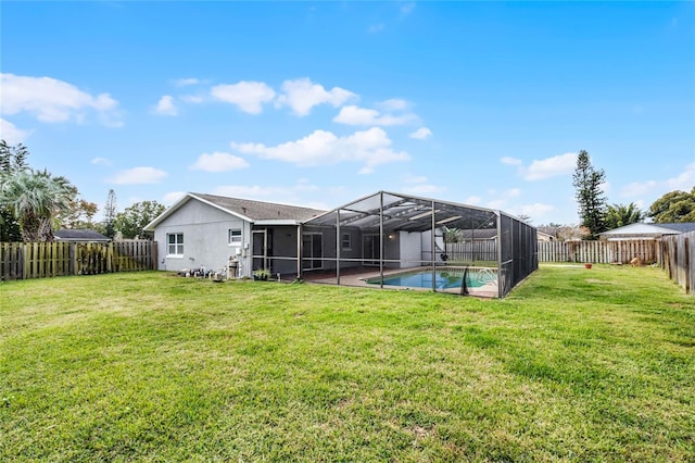 back of property with a fenced in pool, glass enclosure, and a lawn