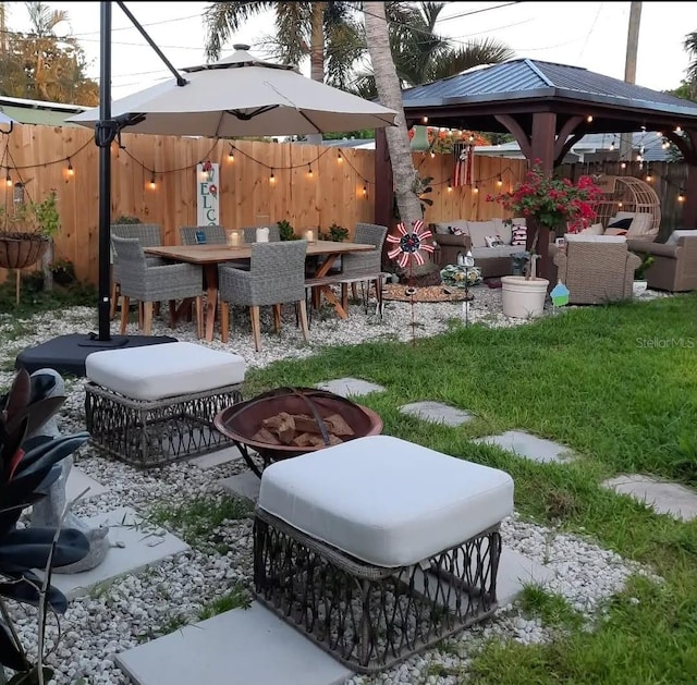 exterior space featuring a gazebo and an outdoor living space with a fire pit