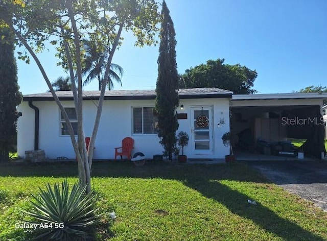 single story home featuring a front lawn and a carport